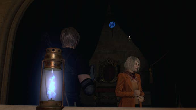 Leon Kennedy และ Ashley ยืนถัดจากเหรียญสีน้ำเงินบนระเบียงคลังอาวุธใน Resident Evil 4