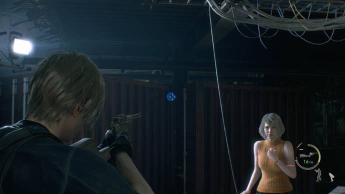 Leon Kennedy a Ashley stojaci vedľa modrého medailónu zavesené na niektorých prepravných kontajneroch v nákladnom sklade v Resident Evil 4