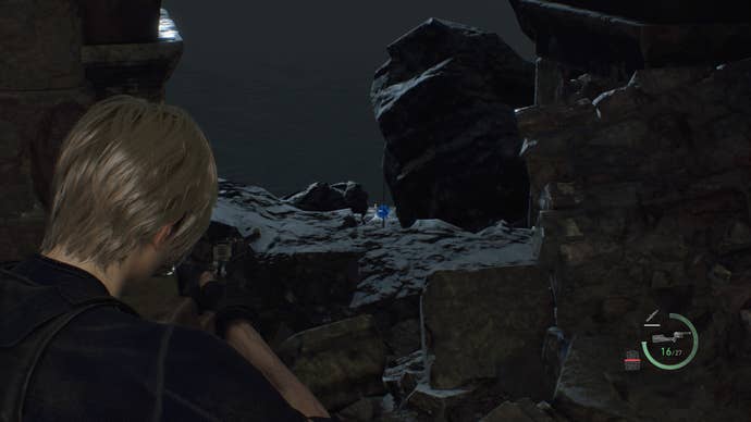 Leon Kennedy apuntando a un medallón azul fuera del costado del camino en las ruinas del acantilado en Resident Evil 4