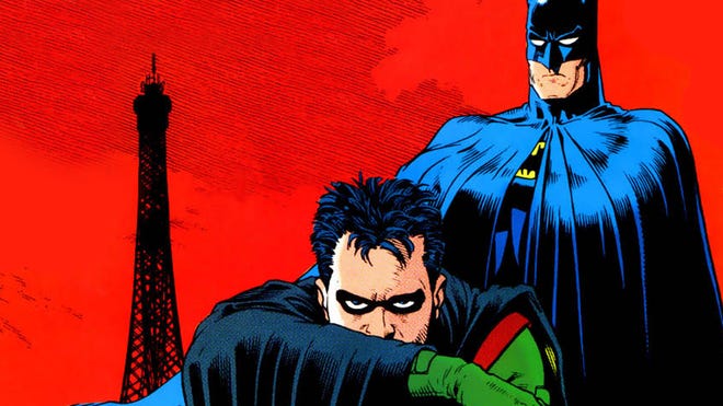 An image of Tim Drake crouching in Robin costume with Batman standing behind him