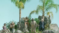Photograph of Samba Schutte, Kristian Nairn, Nat Faxon, Samson Kayo, Matthew Maher in costume standing on an island in Our Flag Means Death, all looking in the same direction
