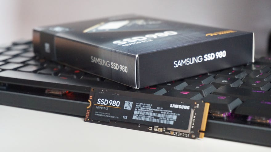 The Samsung 980 SSD propped up against a keyboard next to its retail box