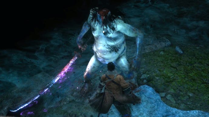 The player faces off against the Headless boss in a misty cave in Sekiro: Shadows Die Twice.