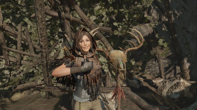 Lara Croft zeigt in „Shadow Of The Tomb Raider“ neben einem gruseligen toten Geweihtotem einen Daumen nach oben