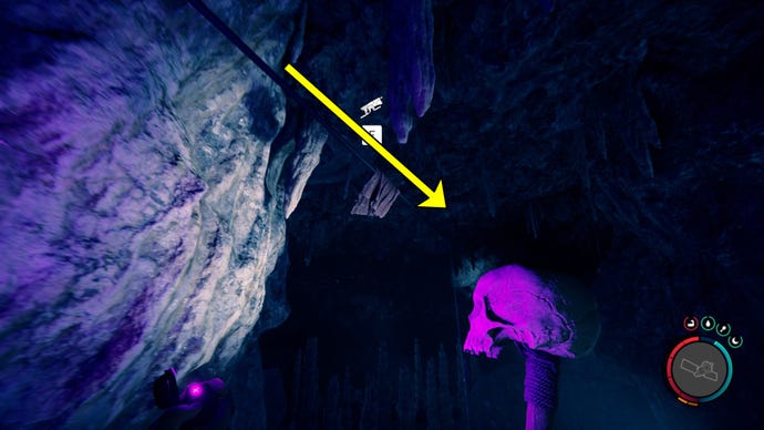 O jogador em Sons of the Forest se prepara para usar a pistola de corda para se apegar a uma tirolesa em uma caverna