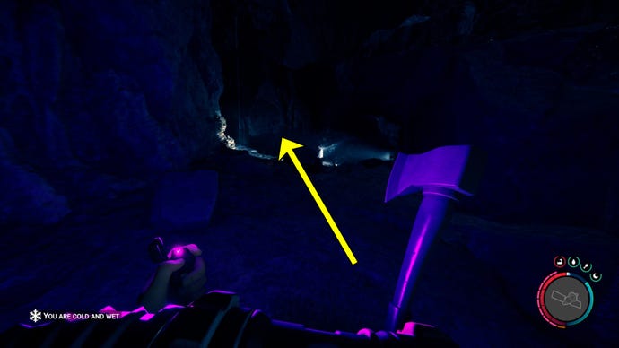 The player in Sons Of The Forest follows a light source in a cave.