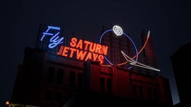 A neon sign for Saturn Jetways looms over a dark city block in a Spectra screenshot.