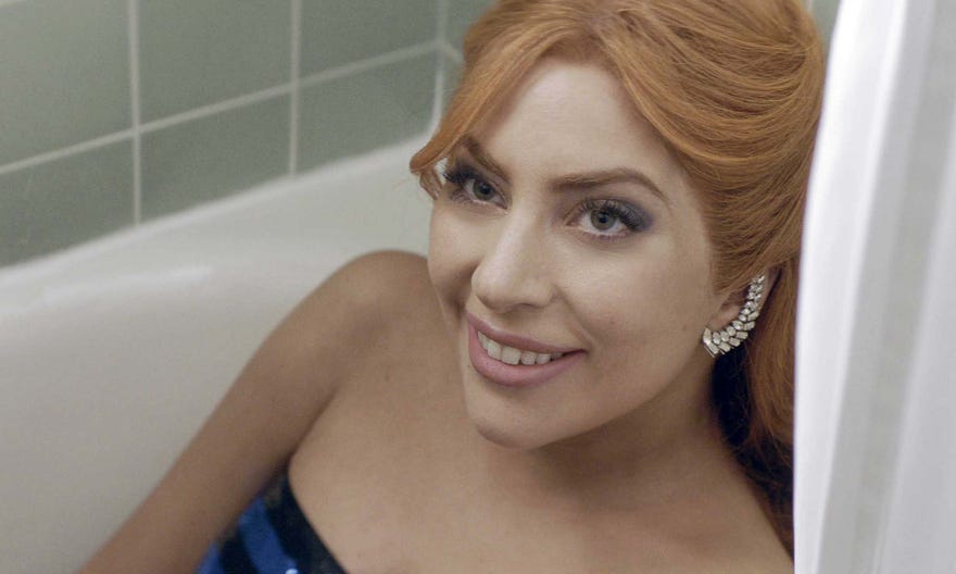 A Star is Born still. Lady Gaga sitting in a bathtub