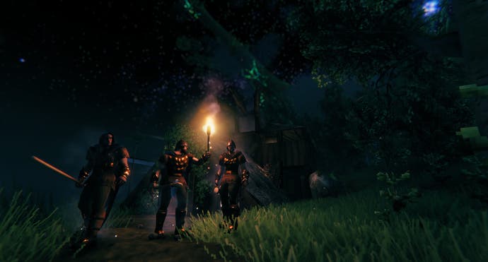 state of the game valheim - exploring as a trio with a torch at night