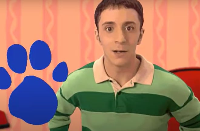 Steve Burns as Steve in Blues Clues looking at audience next to a Blue paw print