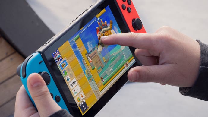 A Switch promotional photo showing an unseen person poking their console's touchscreen with their finger.
