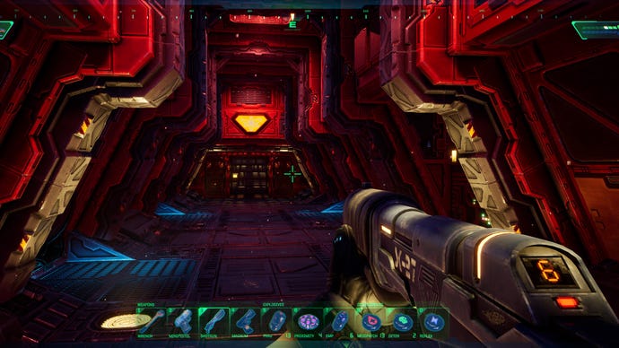 The hacker skulks down an ominous red corridor in the System Shock remake.