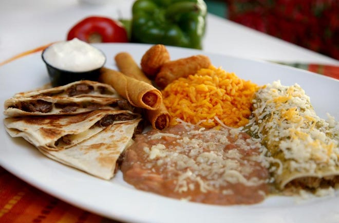 Image of a plate of food including taquitos, beans, and enchiladas