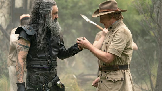 A Photograph of Taika Waititi and Rhys Darby as Blackbeard and Bonnet, they're both looking at a petrified orange in Bonnet's hand