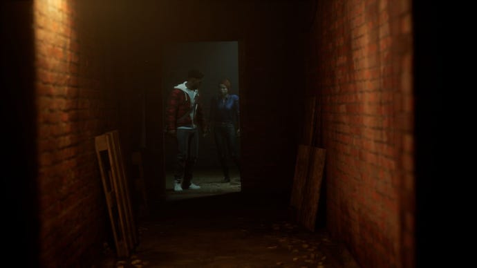 Two characters in The Devil In Me look warily down a dark corridor