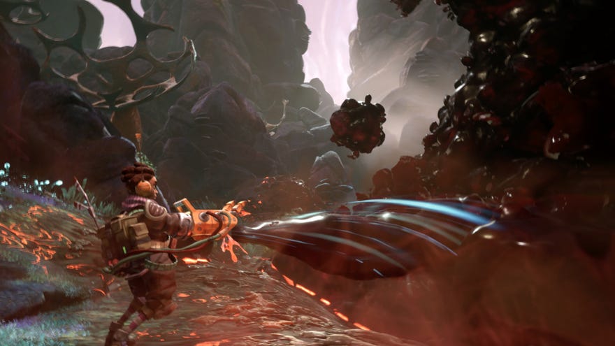 A screenshot of The Gunk showing the protagonist hoovering up a mass of black goo on what looks like a rocky alien world.