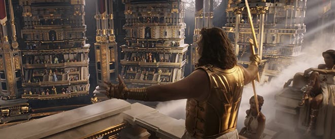 Still from 'Thor: Love and Thunder' Russell Crowe as Zeus is addressing a crowd from a balcony while holding a gold lightning bolt