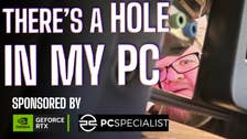 Man peering through a hole in the back of his newly built PC, his face anguished.