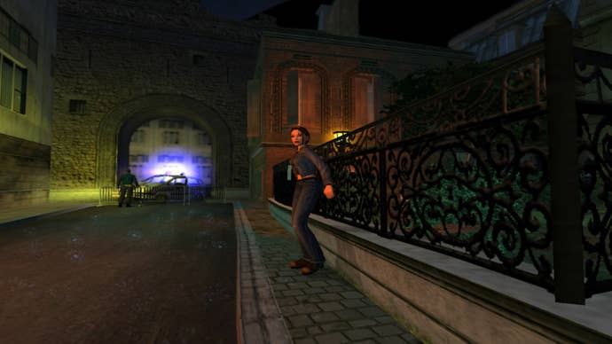 Lara Croft intenta esconderse detrás de una valla en una calle inglesa de aspecto victoriano.  A lo lejos, sirenas.