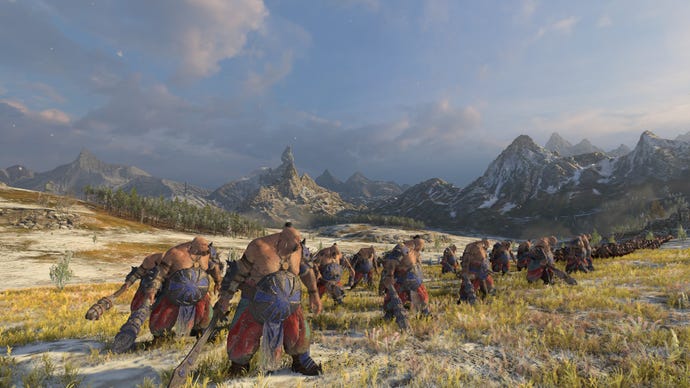 A line of fearsome ogres in Total War: Warhammer 3 standing ready on the battlefield
