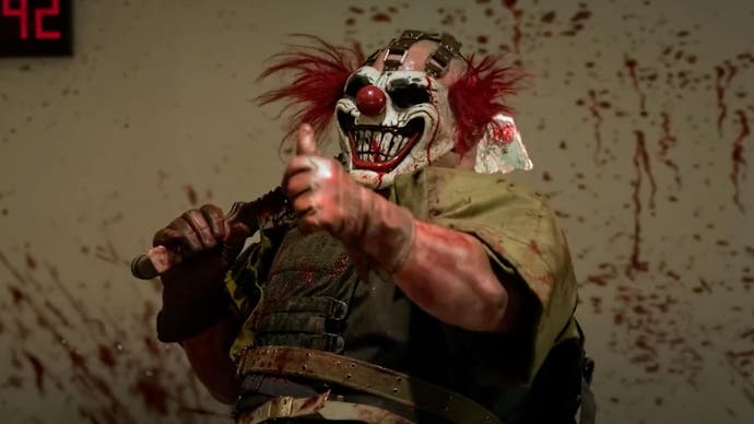 Il clown omicida Sweet Tooth è in piedi contro un muro sporco di sangue con un machete sulla spalla e fa il pollice in su.
