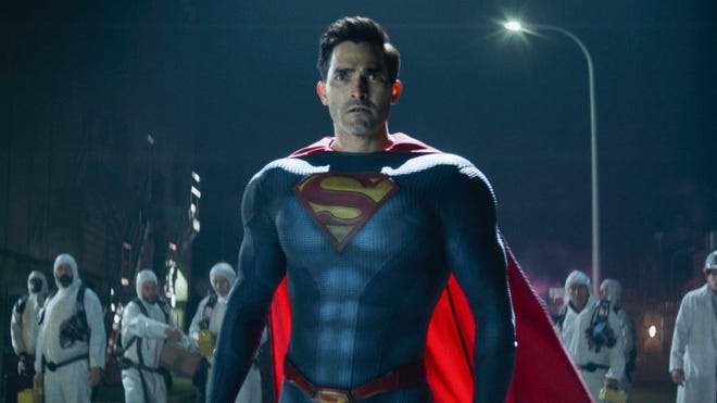 Superman stands in front of a hazmat crew