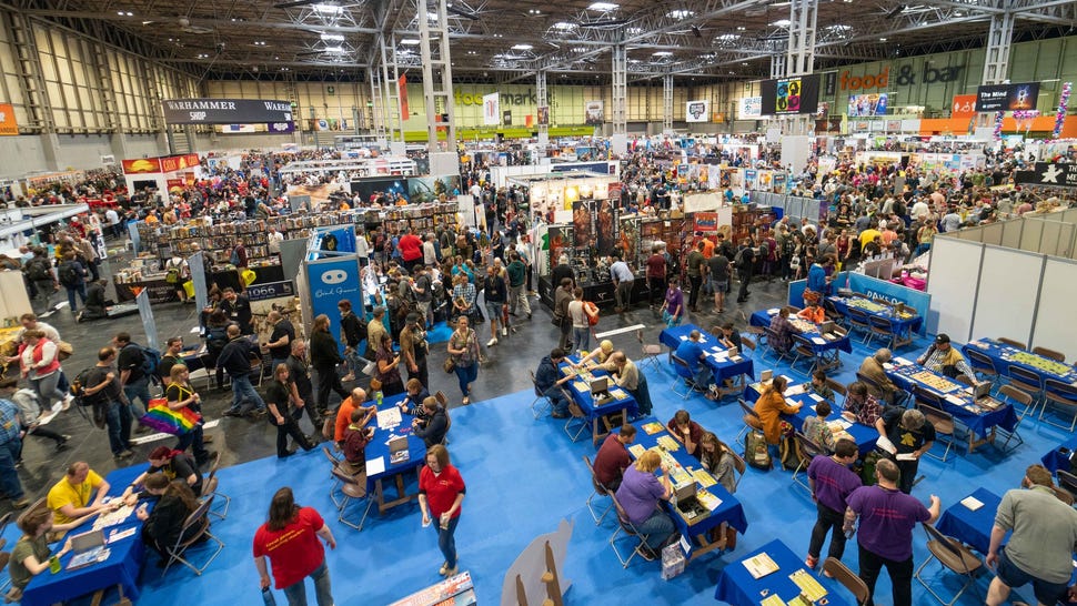 An overhead shot of people walking around tables and along aisles on the UK Games Expo show floor