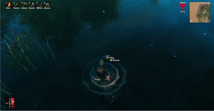 A Valheim screenshot of the player wading into the water to retrieve a piece of Flint on the sea bed.