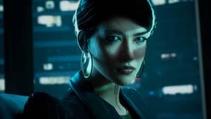 A female vampire wearing a business suit and large earrings stares intensely at the viewer from a backdrop of a nighttime cityscape.
