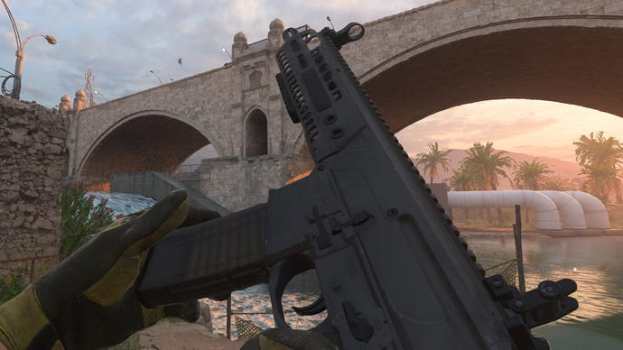 The player in Warzone 2 inspects their weapon, an M13B Assault Rifle.