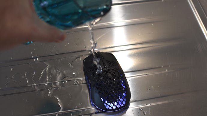 Water being poured from a glass onto the SteelSeries Aerox 3 Wireless mouse, to simulate a spillage.