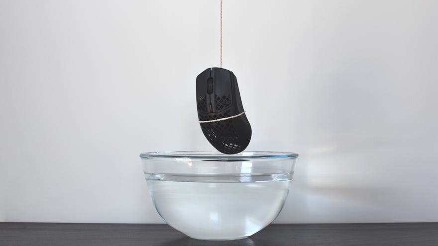 A water-resistant SteelSeries Aerox 3 Wireless Mouse being dangled over a bowl of water.