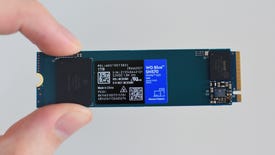 The WD Blue SN570 SSD being pinched between a thumb and finger.