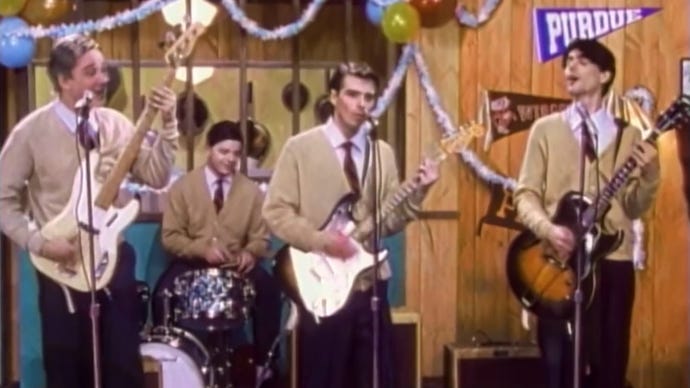 Weezer in the music video to Buddy Holly.
