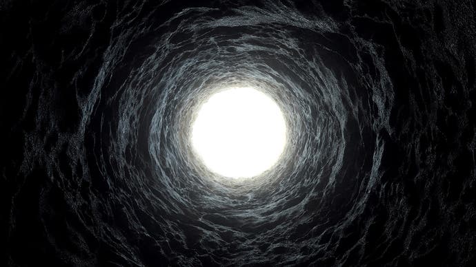 A photograph from the bottom of a well looking up towards the light. It's all darkness apart from the top of the well and some semblance of bricks on it.