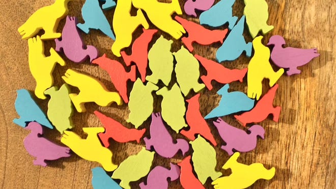 Meeples in the shape of different birds from Wingspan.