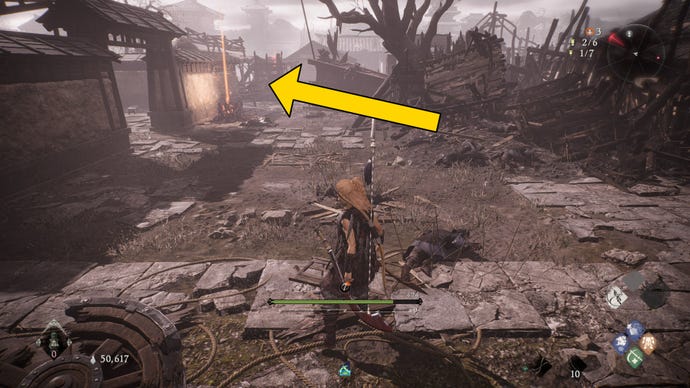 The player in Wo Long stands in front of a Battle Flag on the outskirts of a courtyard.