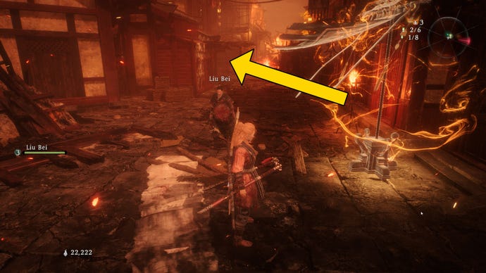 The player in Wo Long stands next to a Battle Flag in the main road of a burning city, with an arrow marking the location of the nearest Shitieshou.