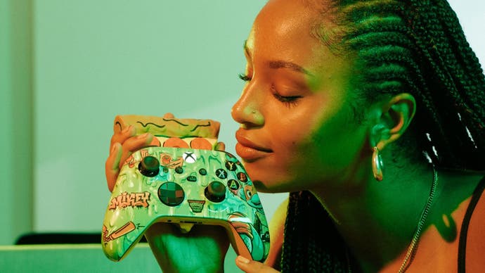 A woman holds the Teenage Mutant Ninja Turtles controller to her face to get a good old sniff of its pizza scent