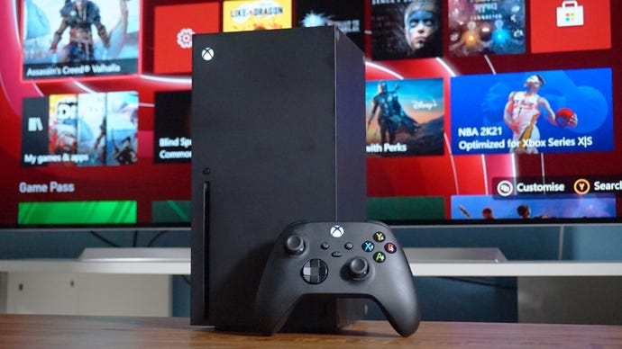 A photo of a black Xbox Series X and controller in front of a TV.