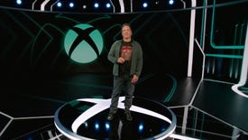 Phil Spencer, in trademark suit jacket with jeans and a logo tee combo, standing on stage at the 2023 Xbox Games Showcase