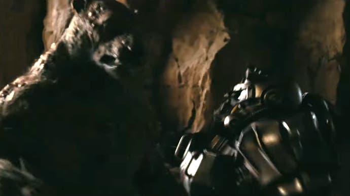 Una persona con servoarmadura luchando contra un yao guai en la serie de televisión Fallout de Amazon
