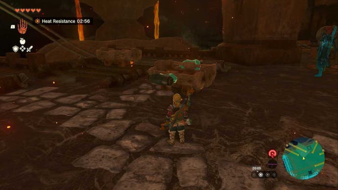 Zelda Totk, Link schaut auf einen Wagen mit zwei Zonai -Raketen auf beiden Seiten, während er auf einer gebrochenen Spur im Feuertempel sitzt
