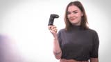 Eurogamer's Zoe Delahunty-Light, standing facing the camera and holding a game controller up.