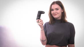 Eurogamer's Zoe Delahunty-Light, standing facing the camera and holding a game controller up.